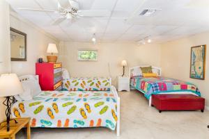 a bedroom with two beds and a ceiling fan at Baybarlyn home in Captiva +27 photos