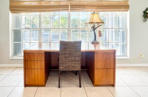 a desk with a lamp and a chair in a room at Baywatch Casa home in Captiva