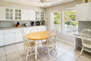 a kitchen with a wooden table and white cabinets at Baywatch Casa home in Captiva +32 photos