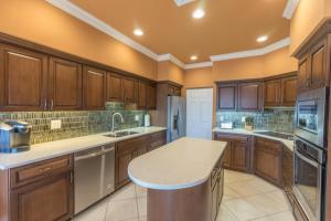 une grande cuisine avec des armoires en bois et un comptoir dans l'établissement Donax condo, à Captiva