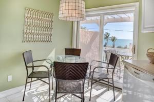 a dining room with a glass table and chairs at Conch-Captiva Beach Villas in Captiva
