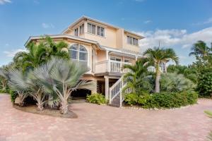 a large house with palm trees in front of it at Conch-Captiva Beach Villas in Captiva