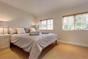 a bedroom with a bed and two windows at April Cottage in East Rudham