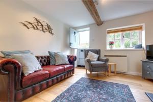a living room with a couch and a chair at April Cottage in East Rudham