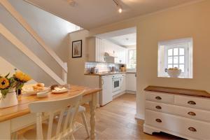 a kitchen with a dining room table and a staircase at April Cottage in East Rudham