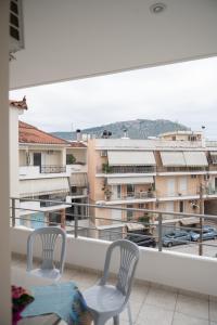 2 sillas en un balcón con vistas a un edificio en Despoina's Lovely Apartment, en Nauplia