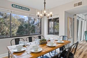 a dining room with a wooden table and chairs at Coastal Oasis with Pool - Walk to Coligny Beach Park in Hilton Head Island
