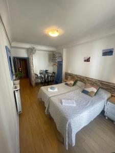 Habitación con 2 camas y mesa. en Gurtxu Rooms by Sun Sebastián, en San Sebastián