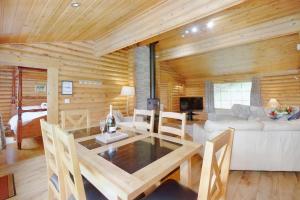 a dining room and living room with a wooden wall at Faweather Grange in Bingley