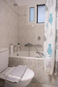 y baño con bañera, aseo y cortina de ducha. en Despoina's Lovely Apartment, en Nauplia 39 fotos más