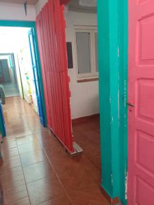 Habitación con puertas rojas y verdes y suelo de baldosa. en Ruuhma en Salta