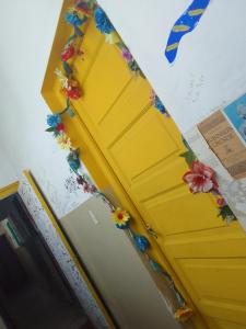 Una puerta amarilla con flores. en Ruuhma en Salta