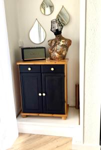 a black cabinet with a mirror on a wall at 'Cap Confession' - Naturiste - Sea View - Beach - Parking -Air Conditionaire in Cap d'Agde