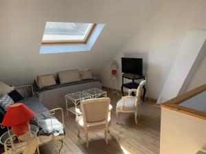 Una sala de estar con una cama y un televisor. en Porte de Paris, en Montesson