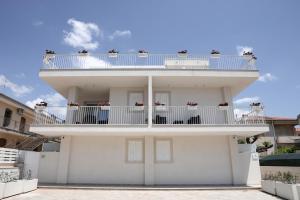 a white house with a balcony on top of it at Keys of Sicily Marina di Modica in Marina di Modica