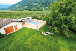 two people sitting on chairs in a yard with a swimming pool at Wiesenheim in Kastelbell-Tschars