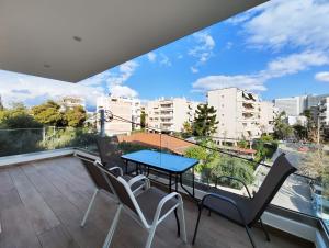 a balcony with a blue table and chairs at Marathonomachon Apartments by Verde Apartments in Athens