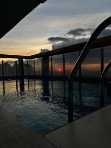 a view of the sunset from a swimming pool at Cozy Spacious Hotel Type Condo with PS5 Smart TV and WiFi in Manila