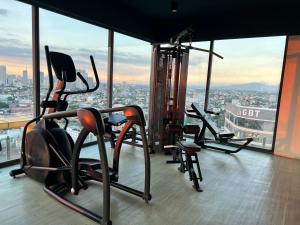 a gym with cardio equipment on top of a skyscraper at Cozy Spacious Hotel Type Condo with PS5 Smart TV and WiFi in Manila