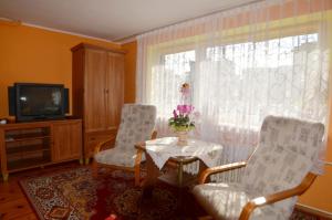 グダニスクにあるApartament Mickiewiczaのリビングルーム(椅子2脚、テーブル、テレビ付)