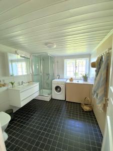 a bathroom with a sink and a washing machine at Storsand Gård in Trondheim