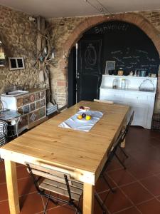 einen Holztisch in einem Zimmer mit Küche in der Unterkunft b&b ocagiuliva in Riparbella