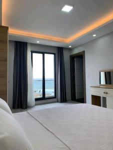 a large bedroom with a large bed and a large window at Renaissance Apart Hotel in Trabzon