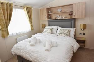 a bedroom with a large white bed with towels on it at Benamara in Ryde