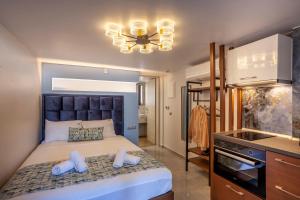 a bedroom with a large bed and a kitchen at Olia seaside residence 120m from the beach in Pefkochori