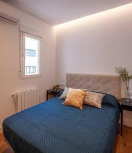 a bedroom with a blue bed with two pillows on it at Luxury flat Salamanca V in Madrid