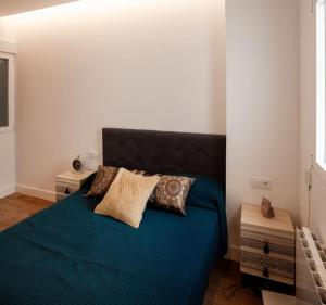 a bedroom with a blue bed with pillows on it at Luxury flat Salamanca V in Madrid