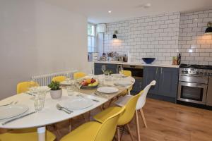 uma sala de jantar com uma mesa e cadeiras amarelas em Arden Villa, sleeps 8, moments from the golden sandy beach of Ryde em Ryde