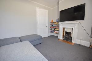 uma sala de estar com um sofá e uma lareira em Arden Villa, sleeps 8, moments from the golden sandy beach of Ryde em Ryde