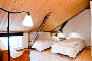 two beds in a room with a wooden ceiling at Rovor och Rum Lägenhet Rännet in Skärhamn