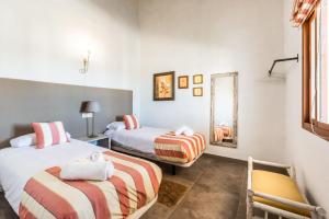 a room with two beds and a chair and a mirror at Apartamento Atalaya Golf I-II-III in Estepona