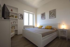een witte slaapkamer met een bed en een raam bij Sunny Flaminio Terrace Penthouse in Rome