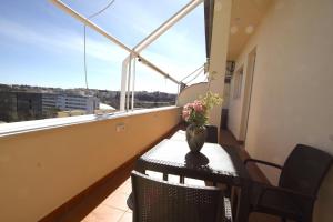 een balkon met een tafel en een vaas met bloemen erop bij Sunny Flaminio Terrace Penthouse in Rome