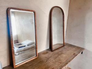 um espelho sentado numa mesa de madeira num quarto em ゲストハウスよるよなか em Nagoia