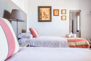 een witte kamer met 2 bedden en een lamp bij Apartamento Atalaya Golf I-II-III in Estepona
