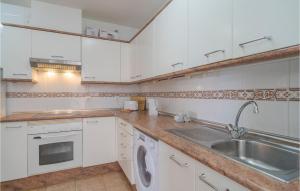 een witte keuken met een wastafel en een vaatwasser bij 2 Bedroom Awesome Apartment In Estepona in Estepona