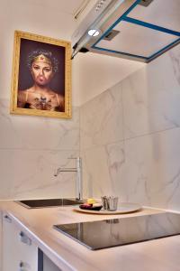 a kitchen with a sink and a picture of a woman at 'Cap Confession' - Naturiste - Sea View - Beach - Parking -Air Conditionaire in Cap d'Agde