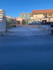 un estacionamiento vacío con una valla y un edificio en LargoDoria - ViaArchivolto, box auto privato incluso, en Albenga
