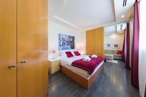 a bedroom with a large bed with red pillows at Cituspace Sandoval in Madrid