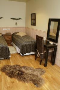 1 dormitorio con cama, escritorio y espejo en Eyjar Fishing Lodge en Breiðdalsvík