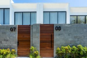 una valla de madera delante de una casa en Oasis Villa 8 by Betterplace, en Canggu