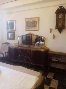 チェリアーレにあるAppartamento al mareの鏡付きのデスク、時計が備わる客室です。