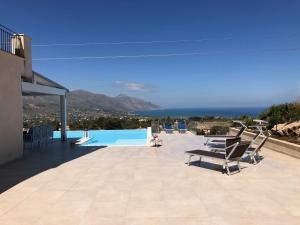 un patio con sillas y una piscina en la parte superior de una casa en Villa MiraScopello, en Castellammare del Golfo