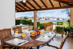 drewniany stół z jedzeniem i szklankami soku pomarańczowego w obiekcie Les Ancores w Alcudii