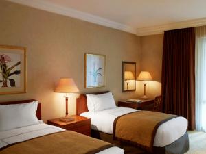 a hotel room with two beds and a window at Sheraton Addis, a Luxury Collection Hotel, Addis Ababa in Addis Ababa