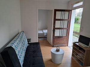 - un salon avec un canapé et une porte menant à une chambre dans l'établissement Vacance solidaire appartement, à La Souterraine